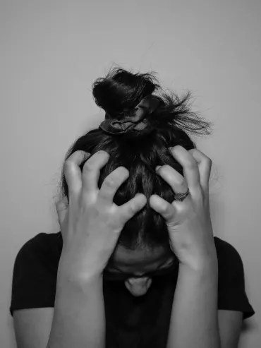 Person overwhelmed by stress representing cortisol dysregulation and fatigue